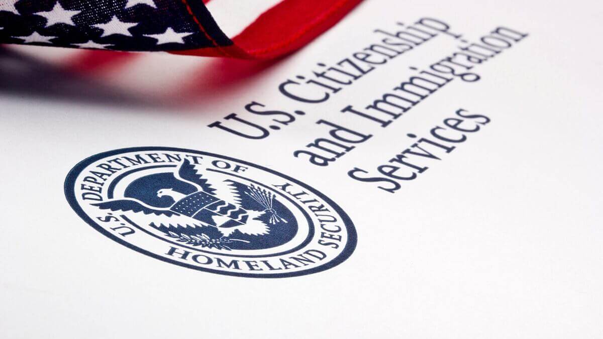 Bandera de Estados Unidos encima de una hoja del departamento de Servicios de Inmigración.