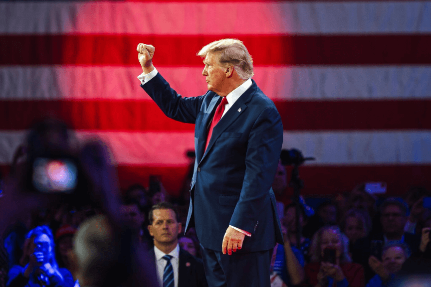 Donald Trump raising his fist at a press conference.