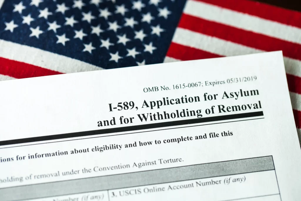 I-589 Asylum Form placed over an US flag