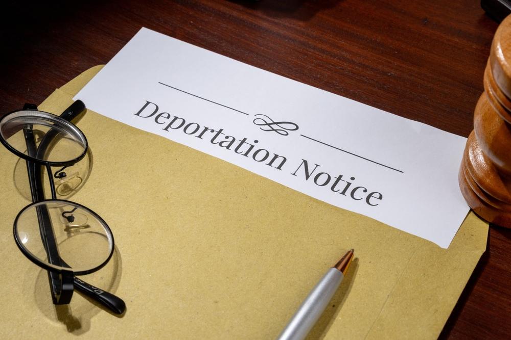 A deportation document on a clipboard beside a gavel and eyeglasses to symbolize the question of whether you can fight a deportation case.