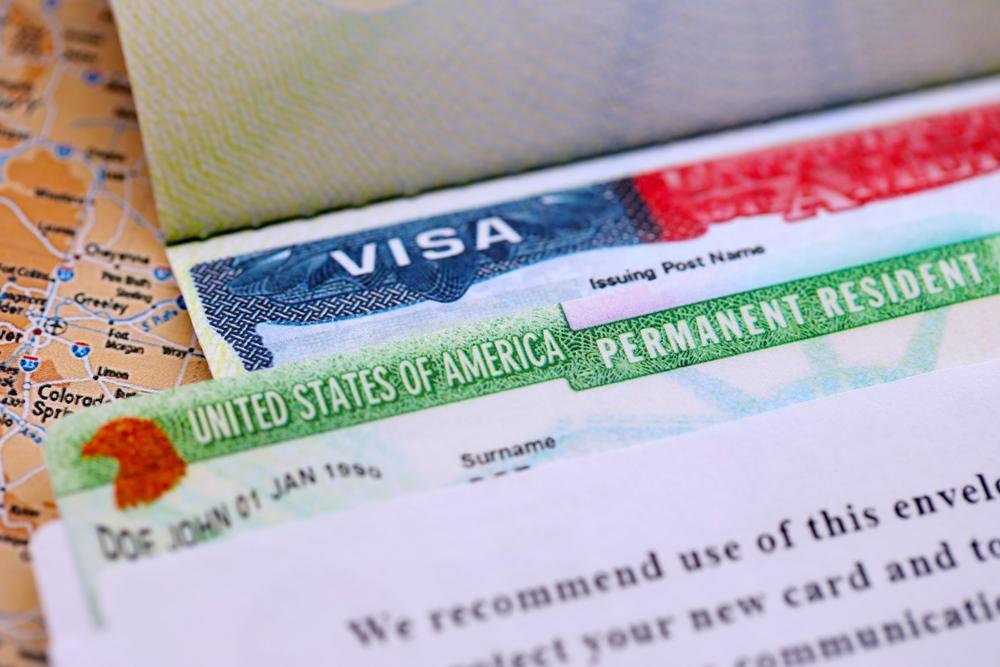 Close-up view of a visa and a permanent resident card, two documents you should carry to avoid deportation.